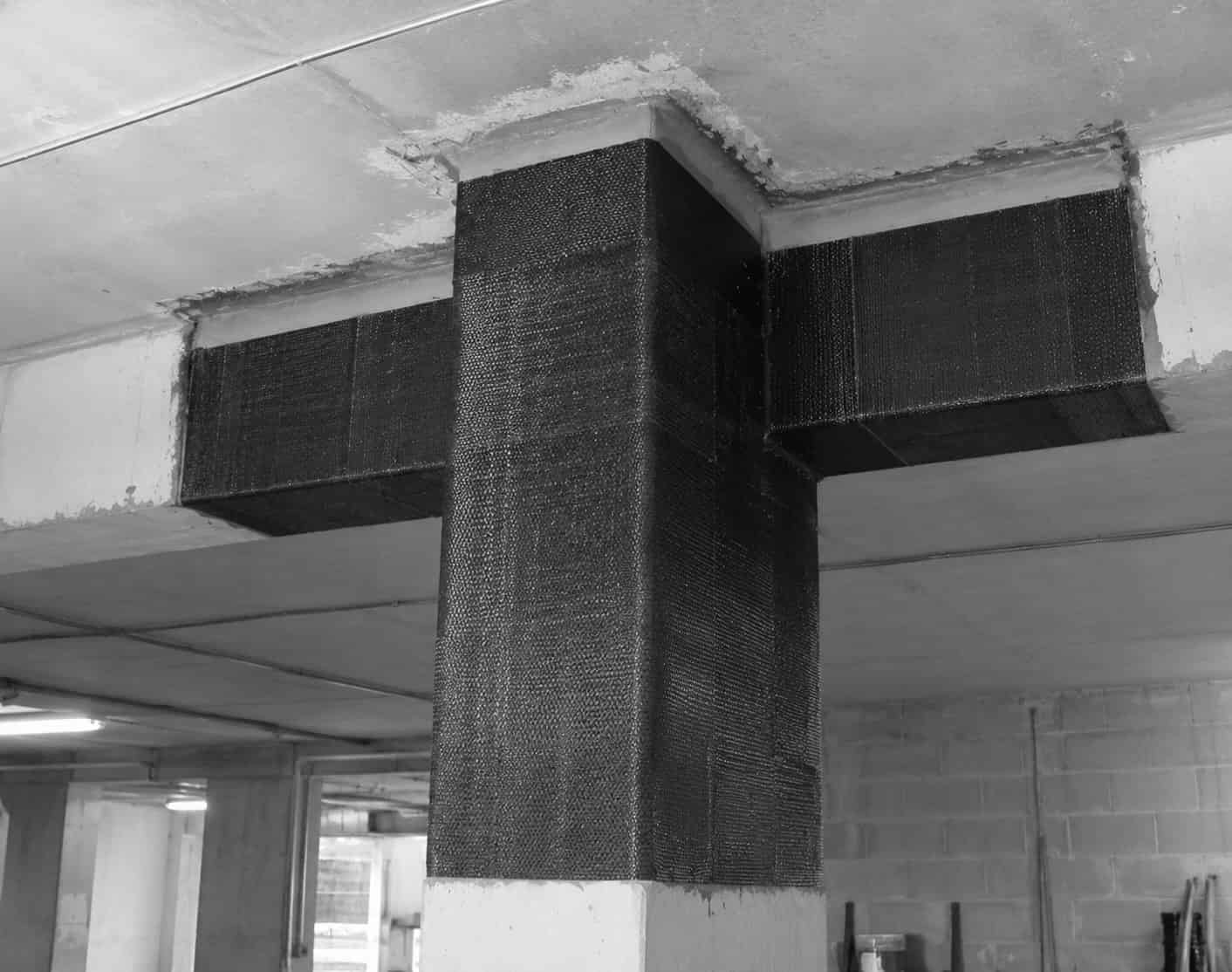 Concrete column and beam under a parking deck wrapped with externally bonded carbon FRP.