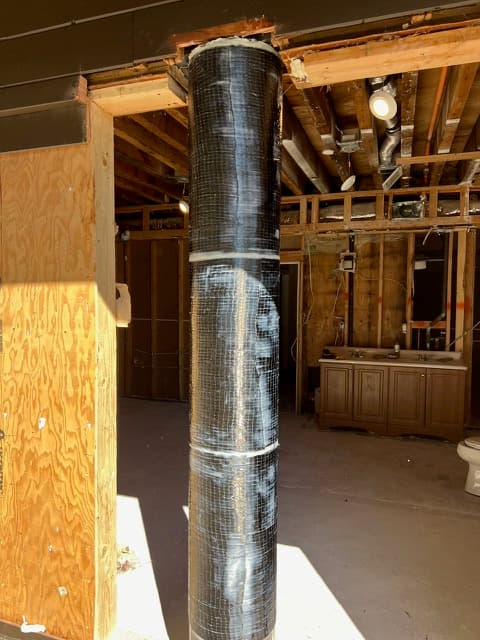 Carbon-fiber fabric bonded to a concrete structural member during a seismic FRP retrofit