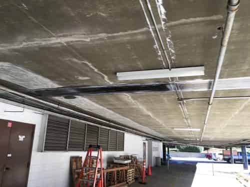 Carbon FRP strip bonded along the underside of a parking-structure slab.