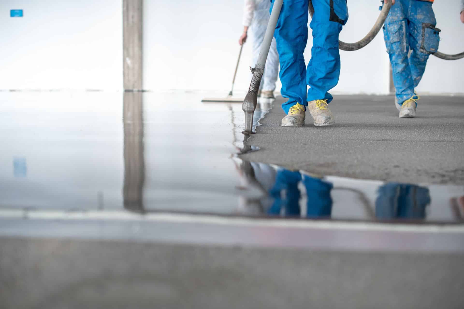 Applicators squeegeeing a poured American-made epoxy resin floor coating
